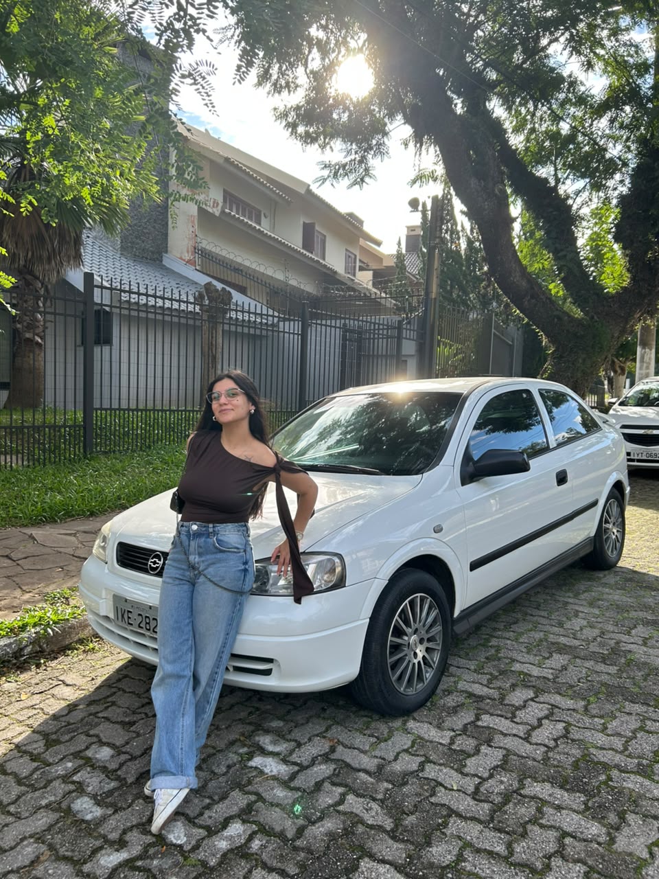 Rafaela sorrindo em frente ao carro